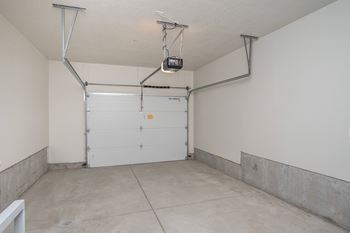 A garage with a white door and a white wall.